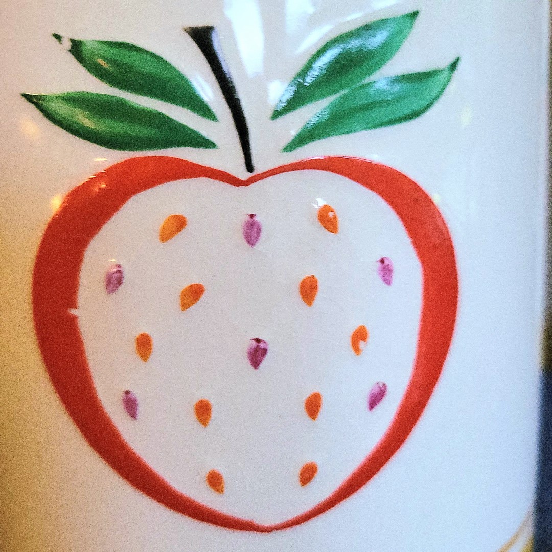 Close-up of strawberry decoration on cookie jar.