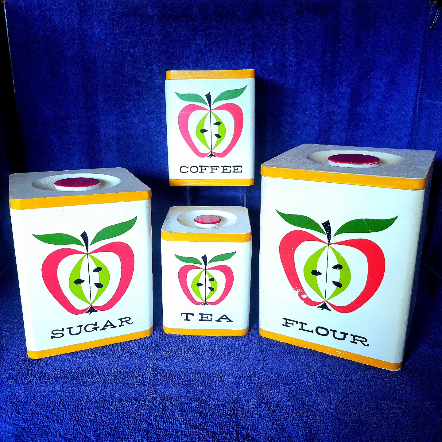 Four-piece wooden canister set: Flour, Sugar, Coffee, and Tea.