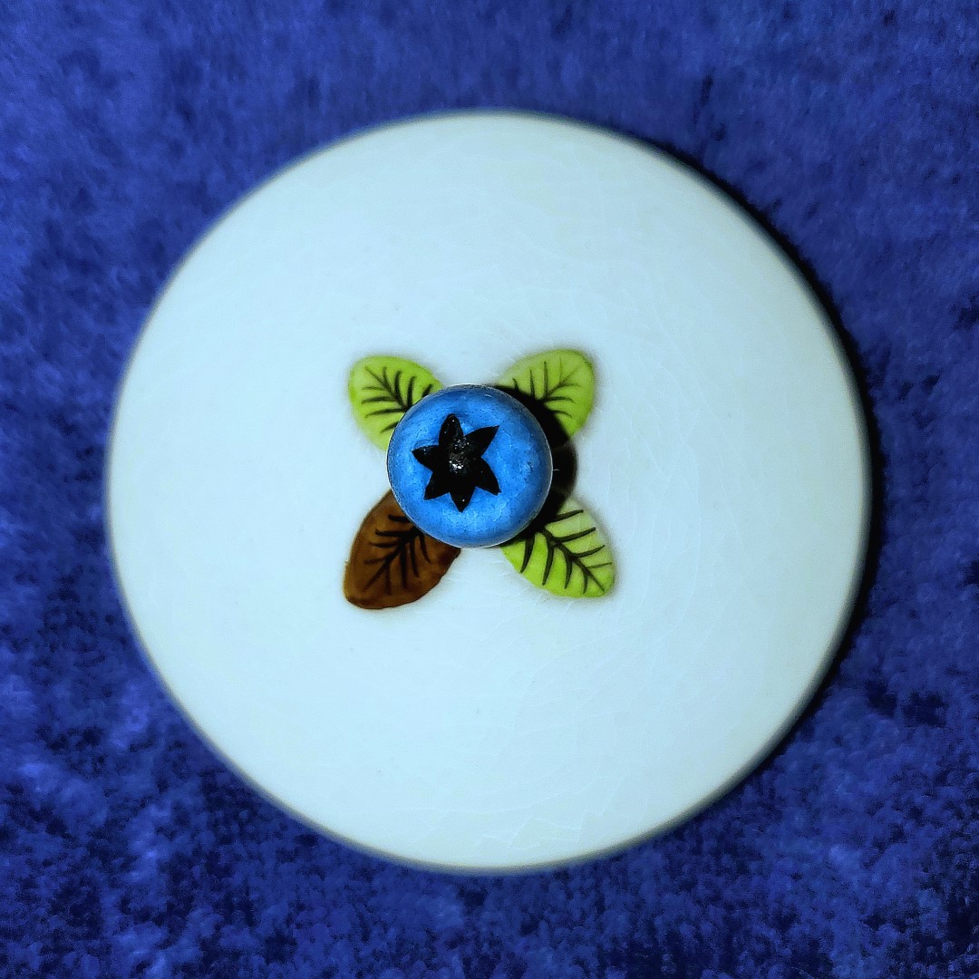 Close-up of Blueberry lid finial with four leaves.