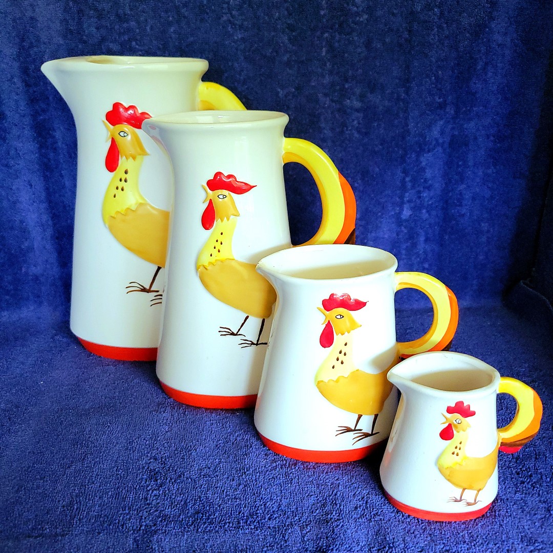 Alternate group view of four Holt Howard Coq Rouge pitchers.