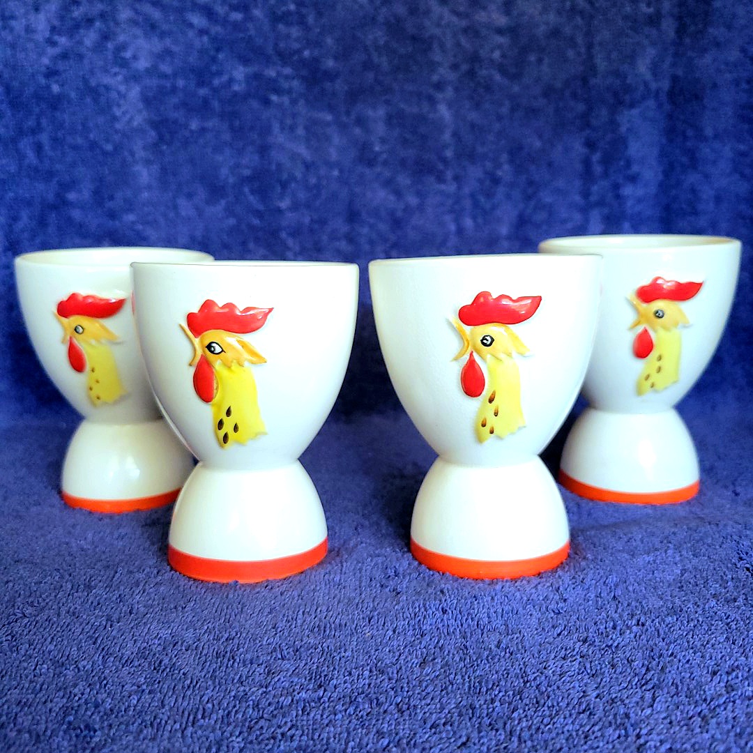 Four reversible Holt Howard Coq Rouge egg cups showing the upright rooster-head decoration.