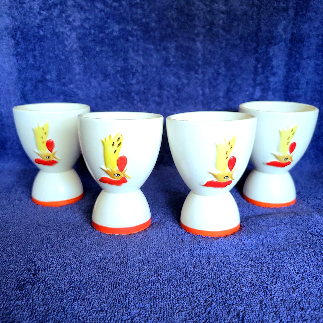 The same four reversible Holt Howard Coq Rouge egg cups rotated 180 degrees, showing inverted rooster-head decoration on the opposite side.
