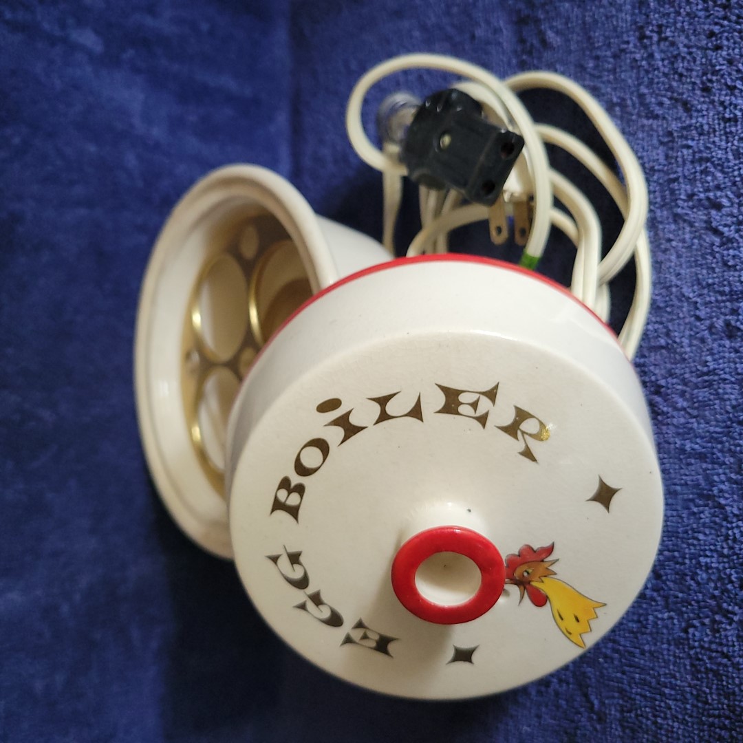 Holt Howard Coq Rouge electric egg boiler opened to show the four-egg metal insert and electrical cord.