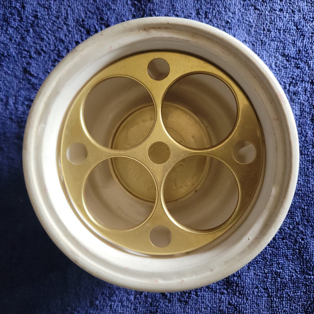 Four-opening metal egg insert inside Holt Howard Coq Rouge electric egg boiler.
