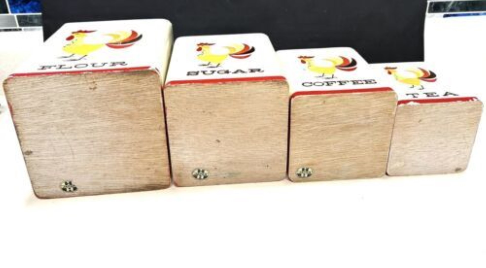 Rear view of the Coq Rouge wooden canister set showing plain wood backs.