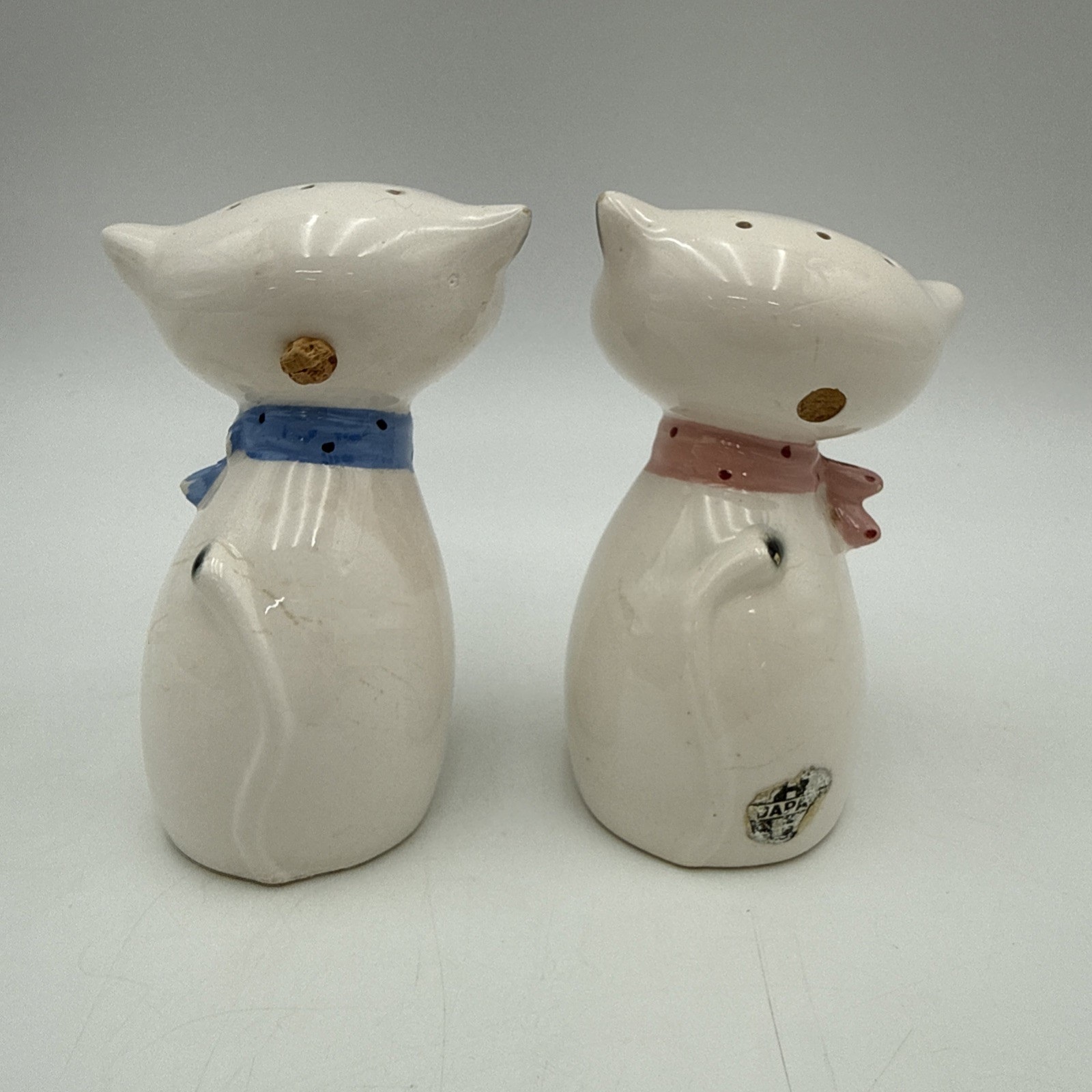 Rear view of Cozy Kittens large-eyed salt and pepper shakers showing refill corks and foil label.