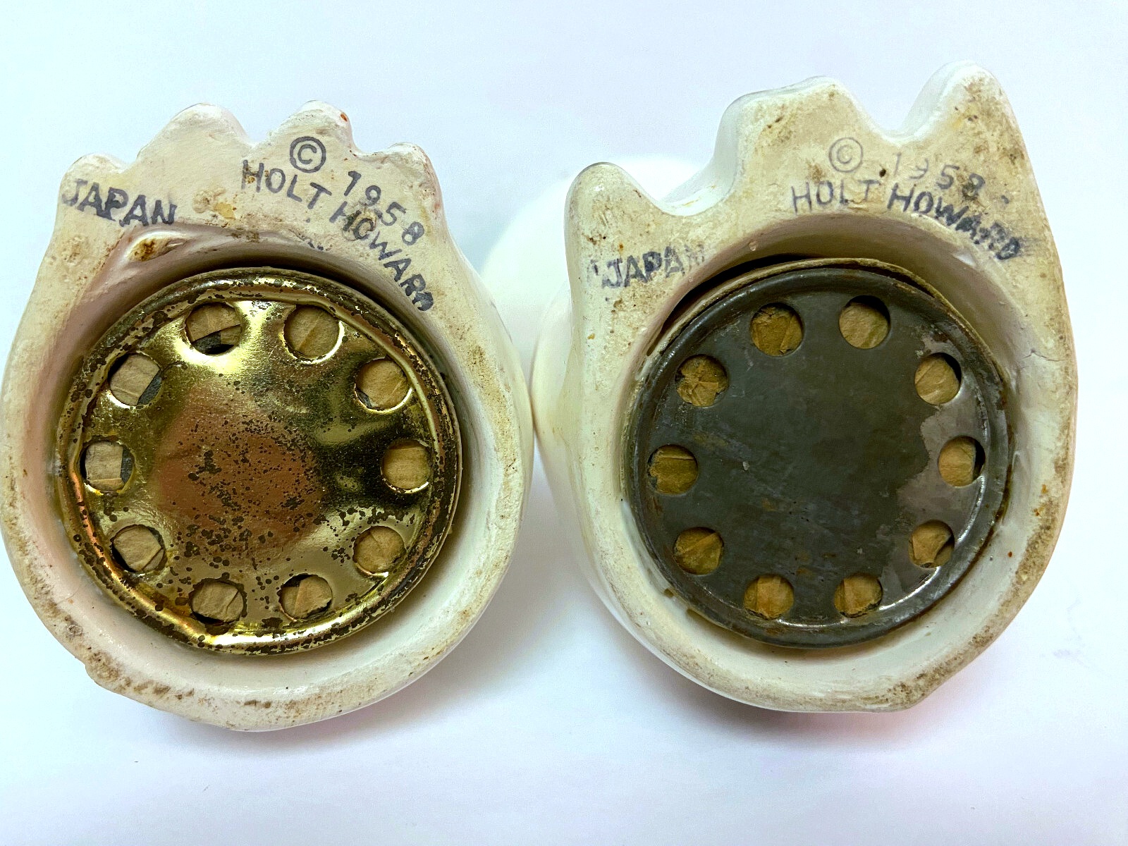 Undersides of Cozy Kittens large-eyed salt and pepper shakers showing 1958 Holt-Howard marks and surviving sound mechanisms.