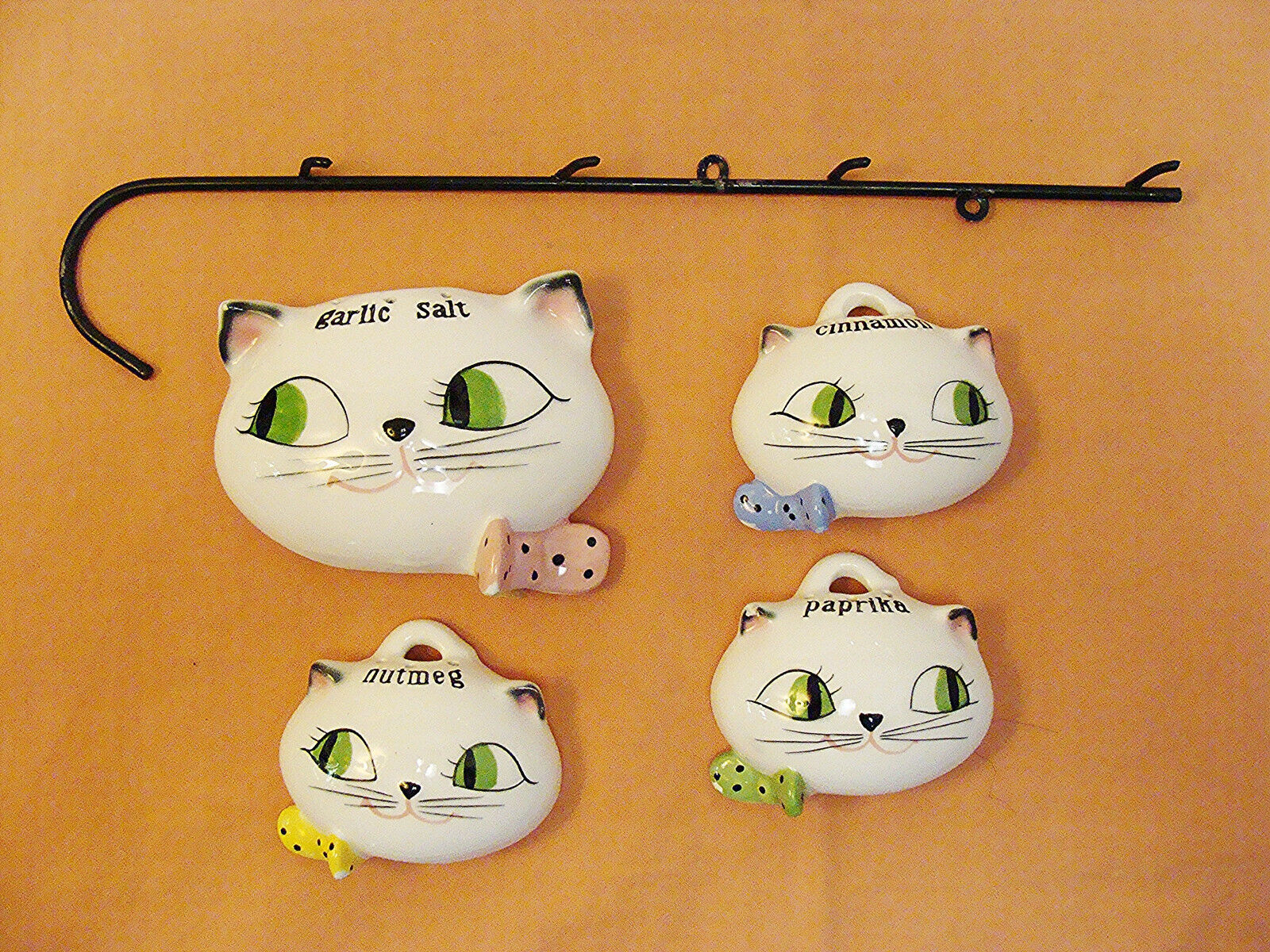 Front view of Holt-Howard Cozy Kittens spice set with Garlic Salt, Nutmeg, Paprika, Cinnamon and wrought-iron rack.