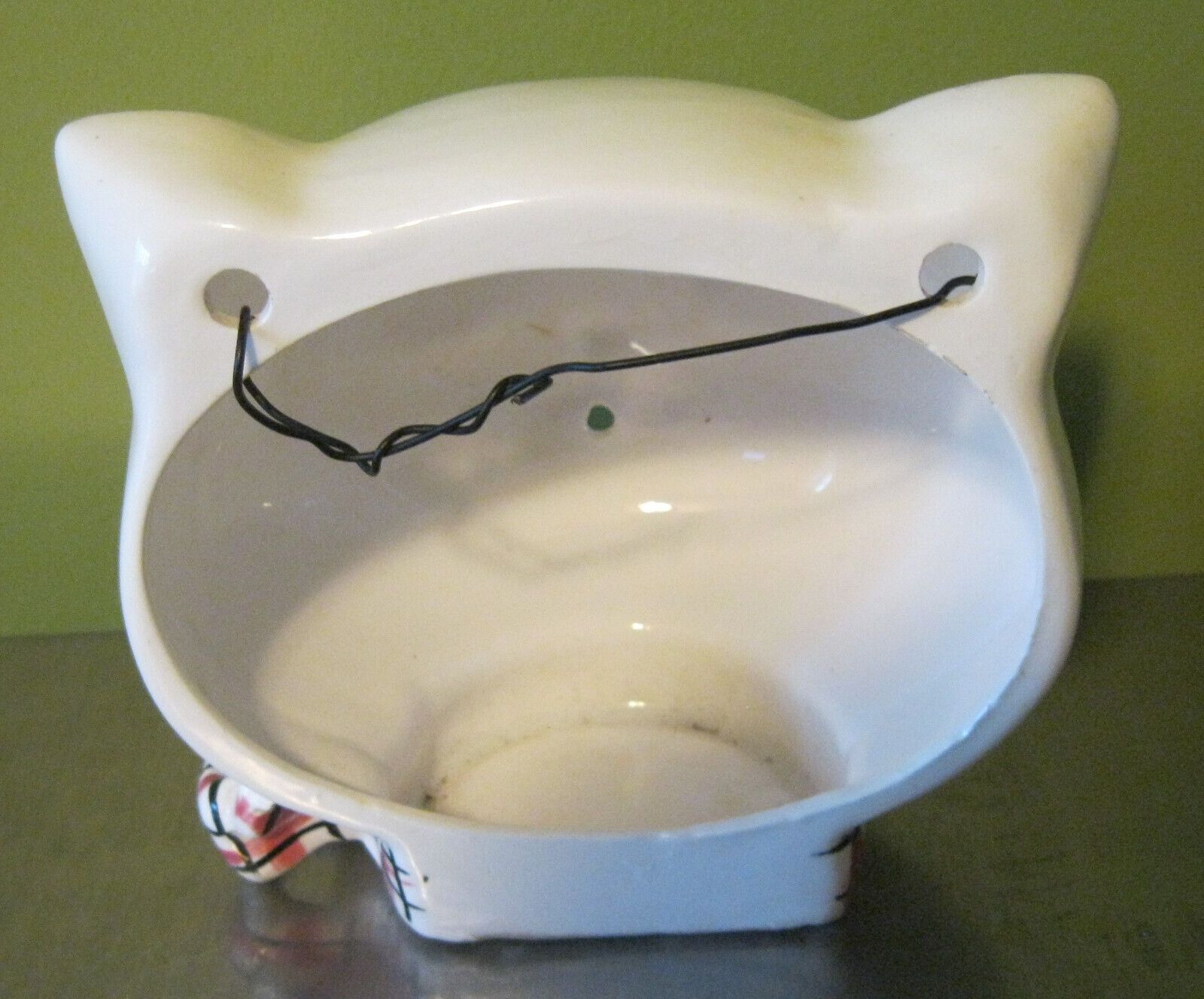 Interior of sideways-looking Cozy Kittens string holder showing wire hanger.